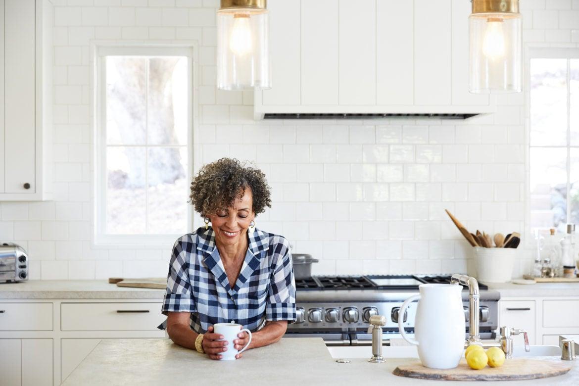 Homeowner drinking coffee in modern kitchen