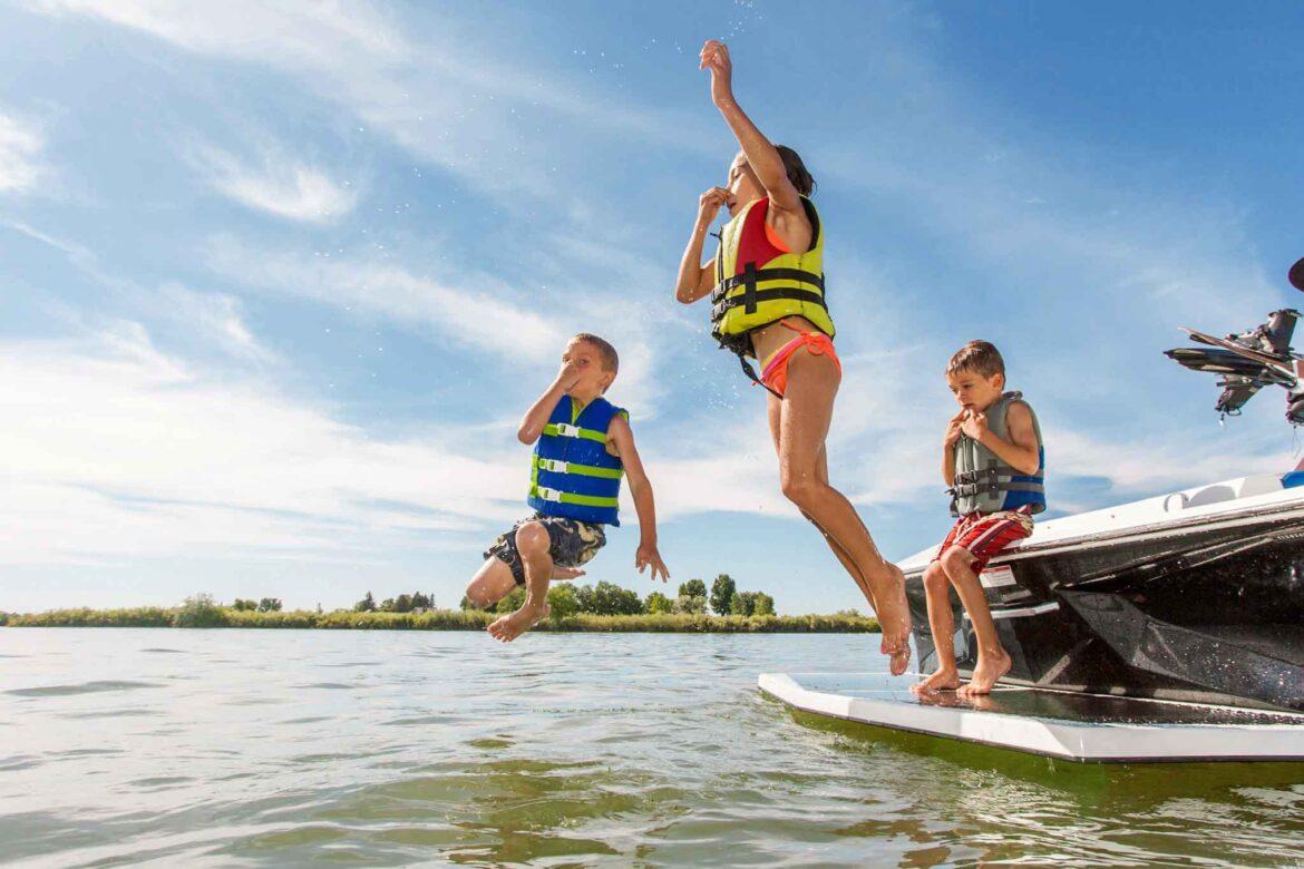 Lake-life-kids-jumping-from-boat-side-1-1170x780