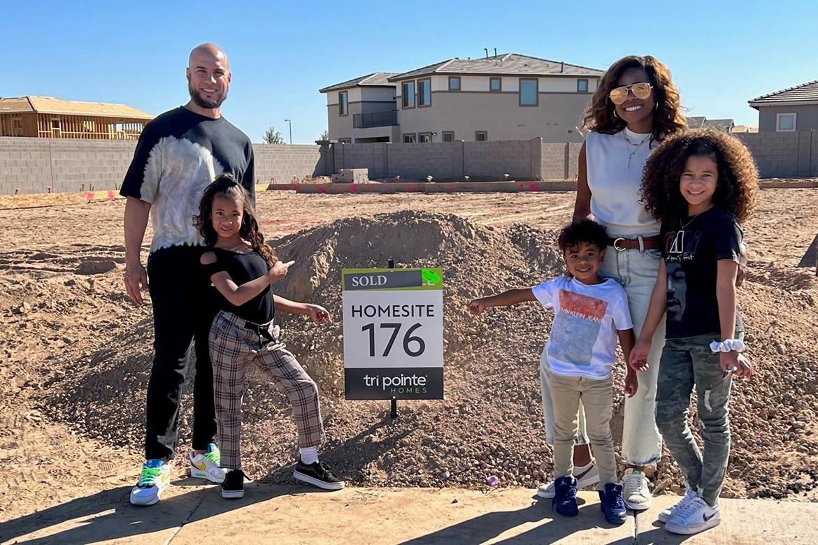happy homeowners with their children standing on their new lot